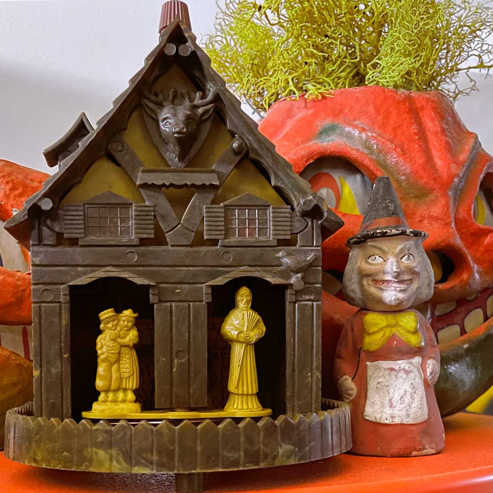 A vintage Weather Forecaster (Hansel and Gretel) shown here with old candy container witch and papier mache Jack O'Lanterns.
